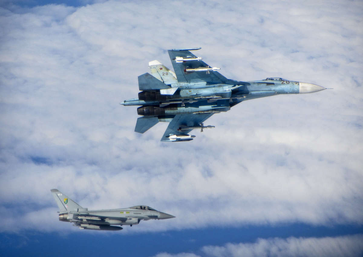 A Russian SU-27 Flanker aircraft banks away with a RAF Typhoon in the background. RAF Typhoons were scrambled on Tuesday 17 June 2014 to intercept multiple Russian aircraft as part of NATOs ongoing mission to police Baltic airspace. The Typhoon aircraft, from 3 (Fighter) Squadron, were launched after four separate groups of aircraft were detected by NATO air defences in international airspace near to the Baltic States. Once airborne, the British jets identified the aircraft as a Russian Tupolev Tu22 Backfire bomber, four Sukhoi Su27 Flanker fighters, one Beriev A50 Mainstay early warning aircraft and an Antonov An26 Curl transport aircraft who appeared to be carrying out a variety of routine training. The Russian aircraft were monitored by the RAF Typhoons and escorted on their way. The Typhoon pilots involved in the operation were Flight Lieutenant (Flt Lt) Mark Long of 29 (Reserve) Squadron (the Typhoon operational training unit) and a French Air Force exchange pilot Commandant Marc-antoine Gerrard who is currently attached to 1(Fighter) Squadron.
